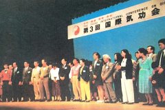 陳樂天大師在第三次國際氣功會議上，對50多位上台受試的國外病患者進行天語特異調理，使30多位患者當場取得明顯效果。右起第四人為先天性耳聾兒童惠下雄太，幾分鐘就听到聲音，引起滿場沸騰。